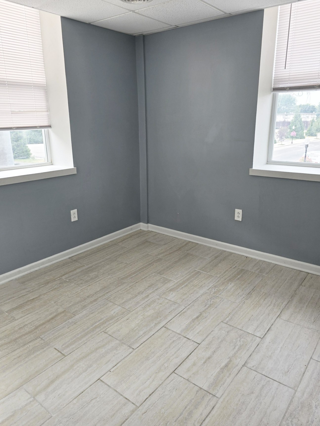 A room with light grey walls and a tiled floor.